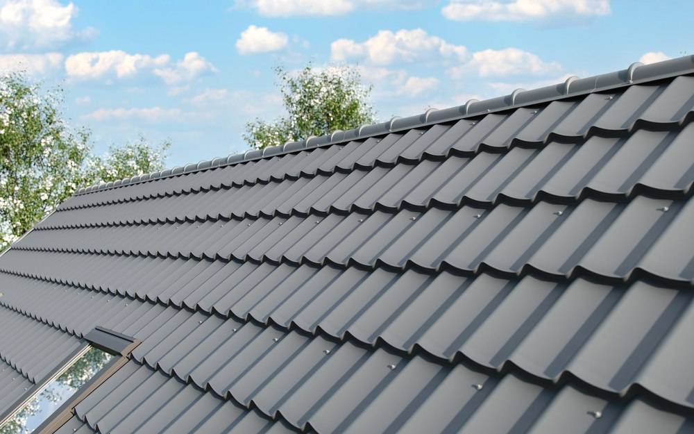 Modern gedecktes Satteldach mit dunkelgrauen Dachziegeln bei blauem Himmel